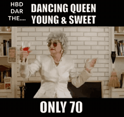 An Elderly Woman Is Holding A Glass Of Wine In Front Of A Fireplace .. GIF