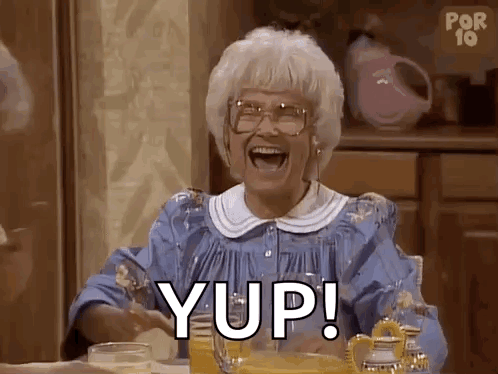 An Elderly Woman Is Sitting At A Table With A Glass Of Orange Juice And A Pitcher Of Orange Juice . GIF