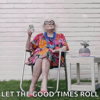 An Elderly Woman Is Sitting In A Chair Holding A Dollar Bill And A Glass Of Beer . GIF