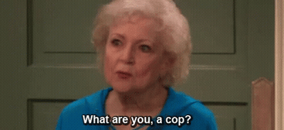 an elderly woman is sitting in front of a door and talking to someone .