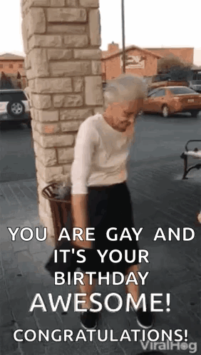 An Elderly Woman Is Standing In Front Of A Brick Wall And Holding A Trash Can . GIF
