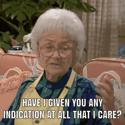 An Elderly Woman Sitting On A Couch Asking If She Has Any Indication At All That She Cares GIF