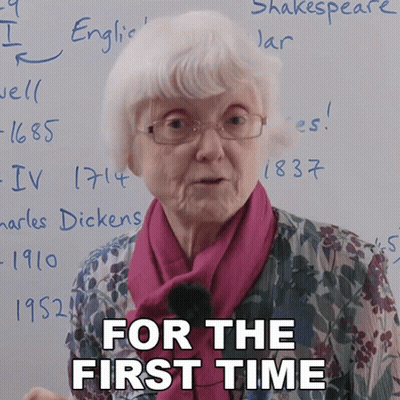 An Elderly Woman Stands In Front Of A White Board With The Words " For The First Time " Written On It GIF