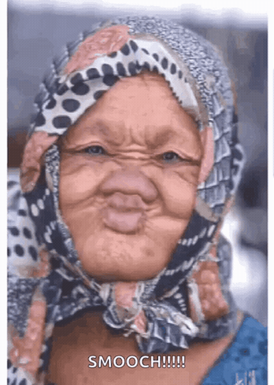 An Elderly Woman Wearing A Scarf On Her Head Making A Funny Face . GIF