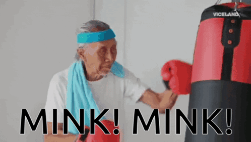 An Elderly Woman Wearing Boxing Gloves And A Headband With The Words Mink Mink On It GIF