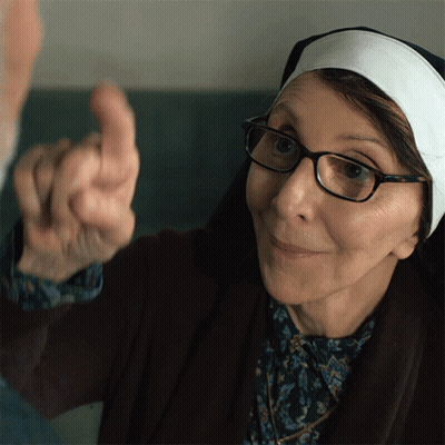 An Elderly Woman Wearing Glasses And A Nun 'S Headband Points Her Finger GIF