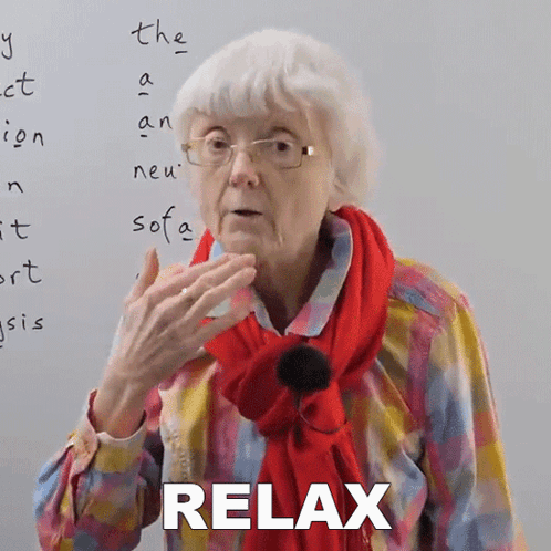 An Elderly Woman Wearing Glasses And A Red Scarf Says Relax In Front Of A Whiteboard GIF