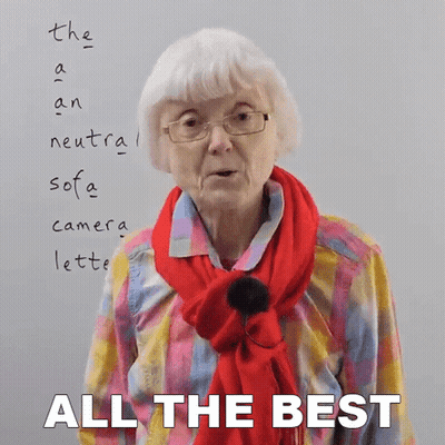 An Elderly Woman Wearing Glasses And A Red Scarf Stands In Front Of A White Board That Says All The Best GIF