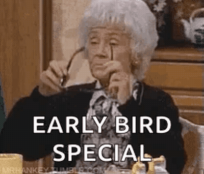An Elderly Woman Wearing Glasses Is Sitting At A Table With A Cup Of Coffee And Says `` Early Bird Special '' . GIF