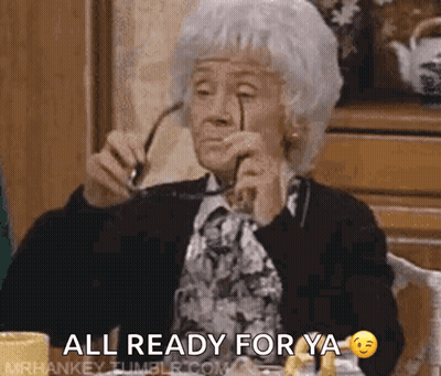 An Elderly Woman Wearing Glasses Is Sitting At A Table With The Words All Ready For Ya GIF