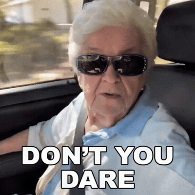 An Elderly Woman Wearing Sunglasses Says " Do N't You Dare " While Driving A Car GIF