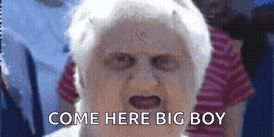 An Elderly Woman With A Scary Face And The Words Come Here Big Boy Written On Her Face . GIF