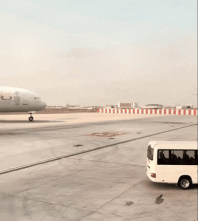 An Emirates Airplane Is Sitting On The Runway GIF