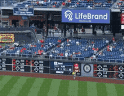 An Empty Baseball Stadium With A Life Brand Sign Above The Stands GIF