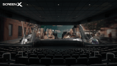 An Empty Movie Theater With A Screen X Logo In The Corner GIF