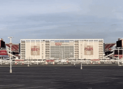 An Empty Parking Lot In Front Of A Large Stadium That Says Levi 'S Stadium GIF
