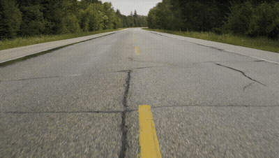 An Empty Road With A Yellow Line On The Side GIF