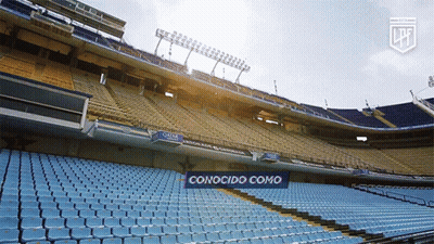 An Empty Stadium With A Blue Sign That Says Conocido Como On It GIF