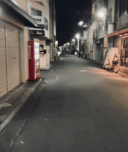 An Empty Street With A Coca Cola Vending Machine On The Side GIF
