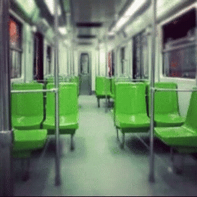An Empty Subway Car With Green Seats And A Door GIF