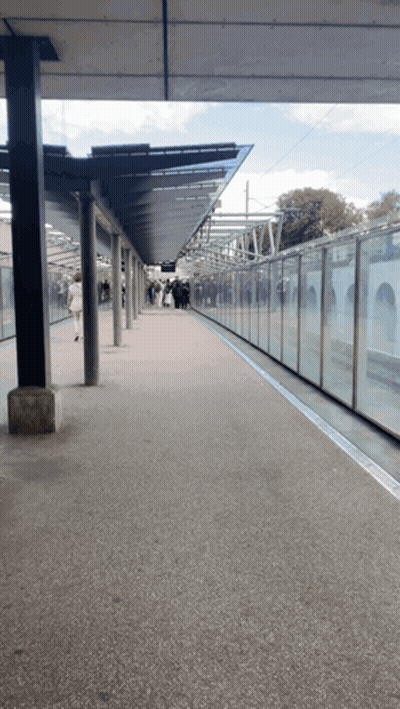 An Empty Train Station With A Glass Wall And A Canopy GIF
