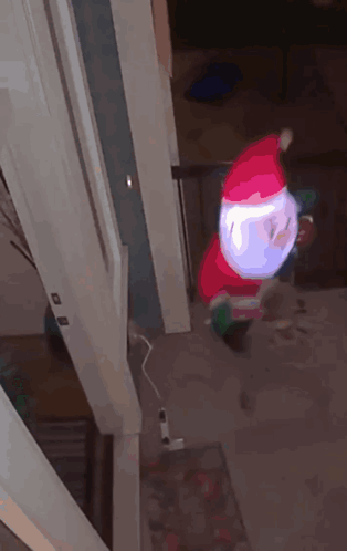an inflatable santa claus is hanging from a doorway