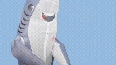 An Inflatable Shark With The Words " I Can 'T Hear You " Above It GIF