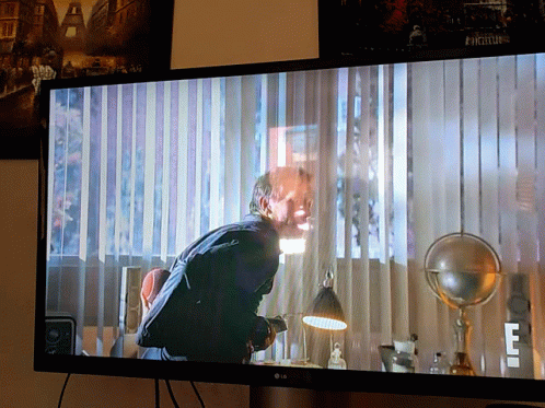 An Lg Tv Shows A Man Hanging Upside Down In A Room GIF