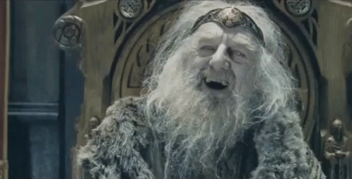 An Old Man With A Beard And A Crown Is Sitting On A Throne And Smiling . GIF