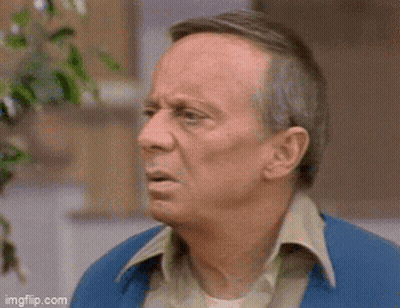 An Older Man In A Blue Jacket Is Making A Funny Face . GIF