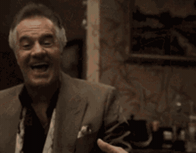 An Older Man In A Suit And Tie Is Laughing GIF