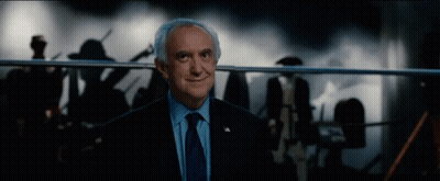 An Older Man In A Suit And Tie Is Smiling GIF