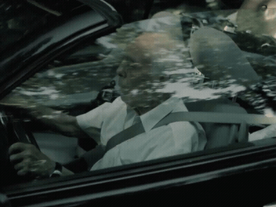 An Older Man Is Driving A Car With A Seat Belt On GIF