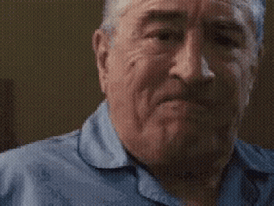 An Older Man Is Making A Funny Face With His Mouth Open And His Eyes Closed . GIF