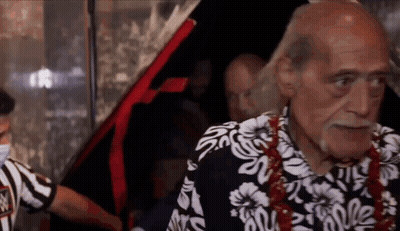 An Older Man Wearing A Hawaiian Shirt Is Standing In Front Of A Car . GIF