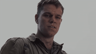 An Older Man Wearing A White Shirt And A Grey Jacket Looks At The Camera GIF