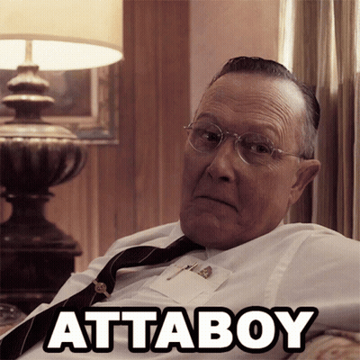An Older Man Wearing Glasses And A Tie Is Sitting On A Couch With The Word Attaboy Written Above Him GIF