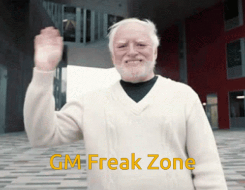 An Older Man With A Beard Is Wearing A White Sweater With The Words Gm Freak Zone Below Him GIF