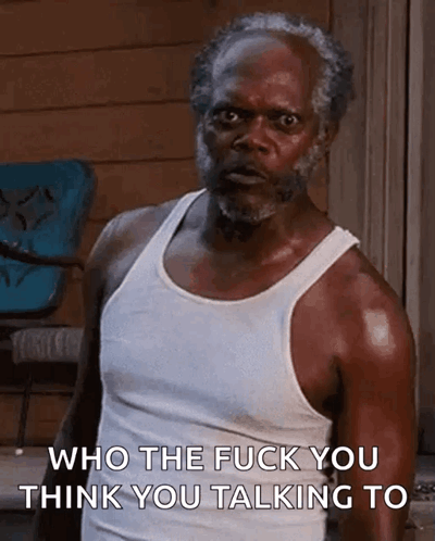 An Older Man With A Beard Is Wearing A White Tank Top And Says Who The Fuck You Think You Talking To . GIF