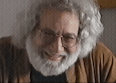 An Older Man With Glasses And A Beard Is Smiling GIF