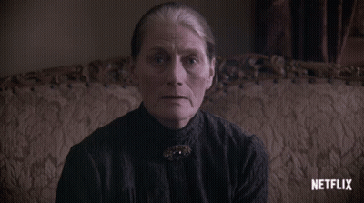 An Older Woman Sitting On A Couch With A Netflix Logo On The Bottom GIF