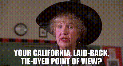 An Older Woman Wearing A Black Hat Says Your California Laid Back Tie-Dyed Point Of View ? GIF