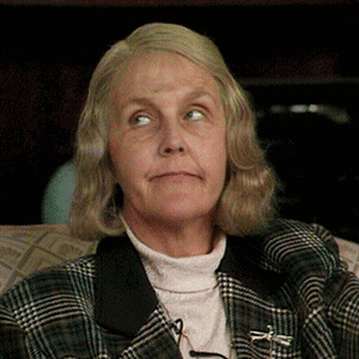 An Older Woman Wearing A Plaid Jacket And A Turtleneck GIF