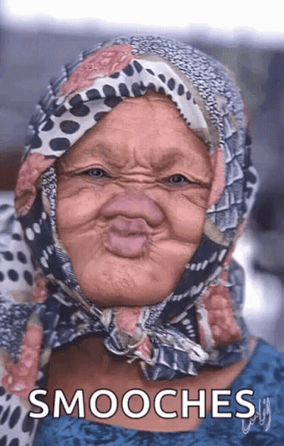 An Older Woman Wearing A Scarf Around Her Head Making A Funny Face And The Words Smooches Below Her GIF