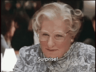 An Older Woman Wearing Glasses And A Floral Shirt Says Surprise . GIF