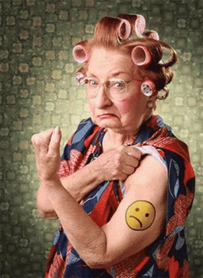 An Older Woman With Curlers On Her Hair Has A Smiley Face Tattooed On Her Arm GIF