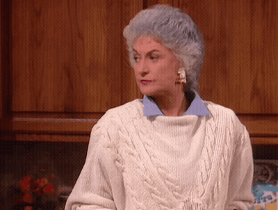 An Older Woman With Gray Hair Wearing A White Sweater GIF