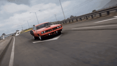 An Orange Car Is Driving Down A Highway With A White Arrow Pointing To The Left GIF