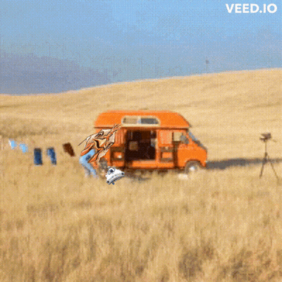 An Orange Van Is Parked In The Middle Of A Field With The Words Veed.io Above It GIF