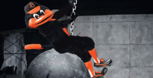 An Orioles Mascot Rides A Bull On A Chain In A Dark Room GIF